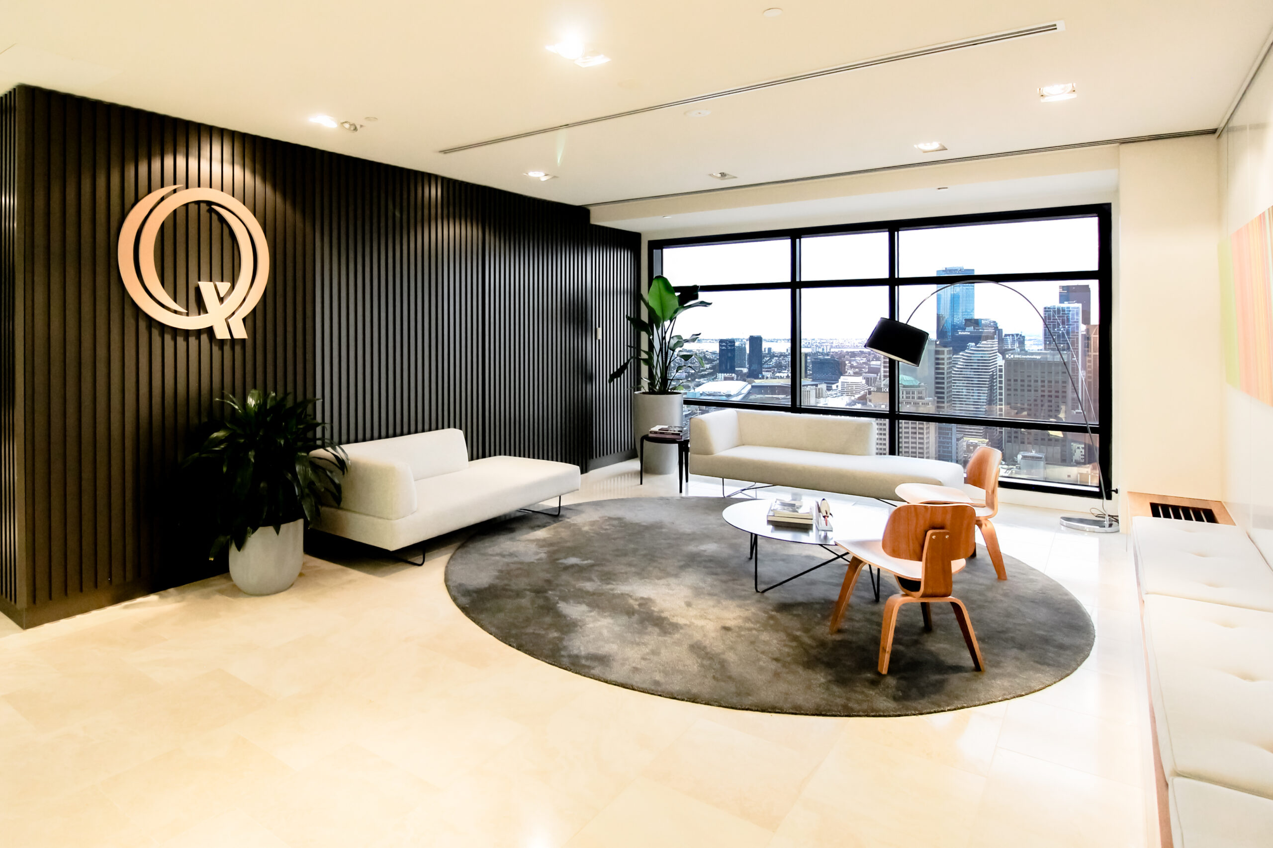 Qualitas Reception Area - a mid-century inspired space with classic funiture sits on a round rug, alongside is a bench seat - a project by Office Vision